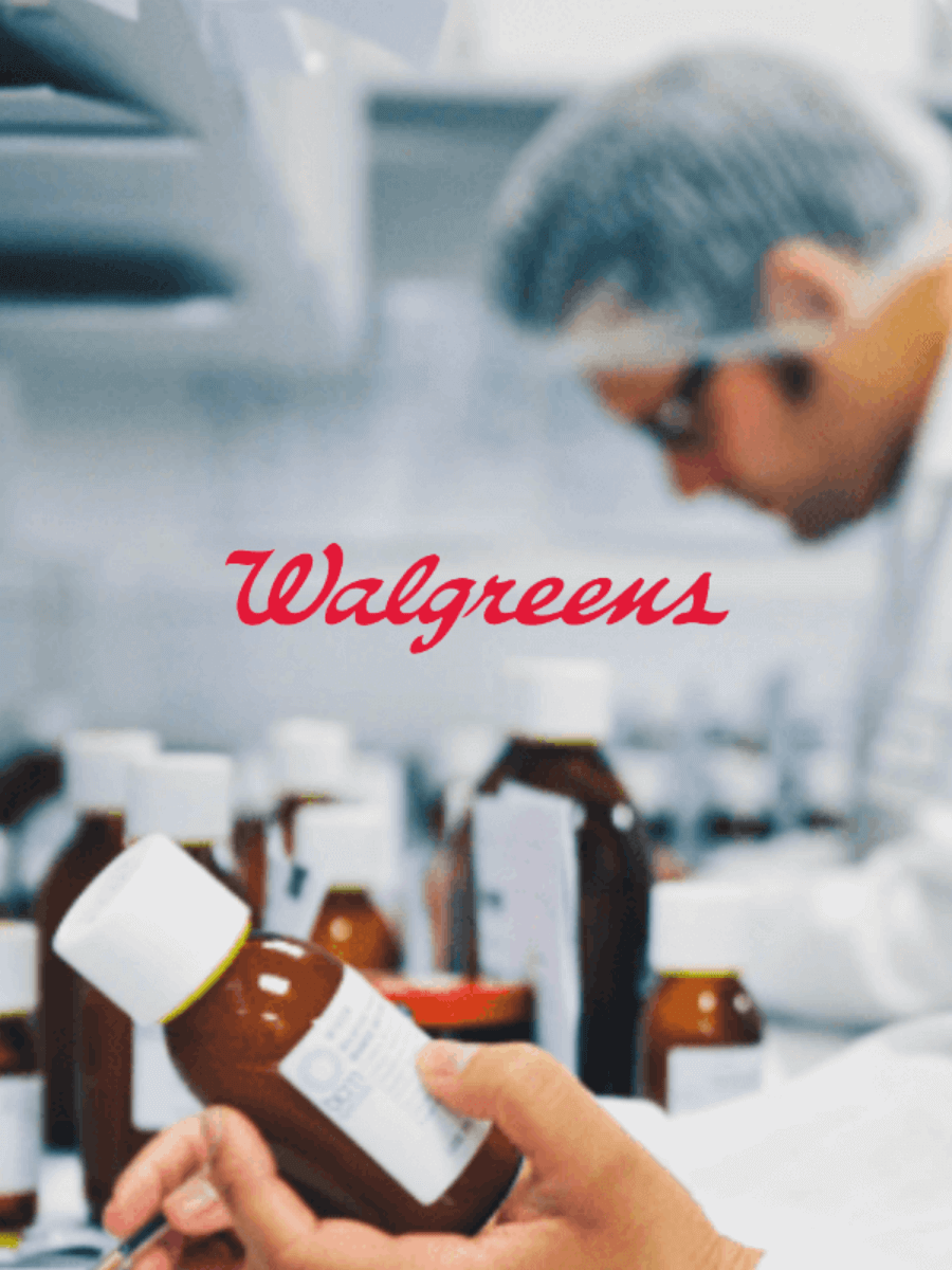 A close-up of a hand holding a prescription bottle with a pharmacist in the background and the Walgreens logo overlayed.